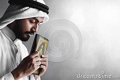 Religious arab muslim man holding holy quran Stock Photo