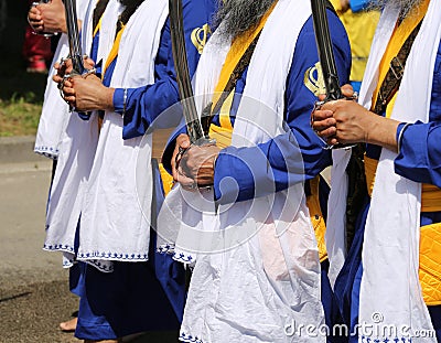 Religious ceremony with Sikh men and swords in hand Editorial Stock Photo