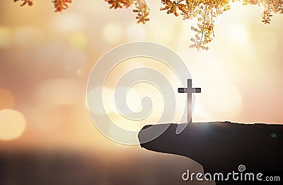 Christian holding the Holy Cross of Jesus Christ on autumn sunset background Stock Photo