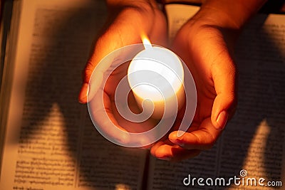 Religious concepts, The young man prayed on the Bible in the room and lit the candles to illuminate Stock Photo