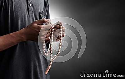 Religious muslim man praying with rosary beads Stock Photo