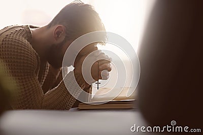 Religious young man praying to God at home Stock Photo