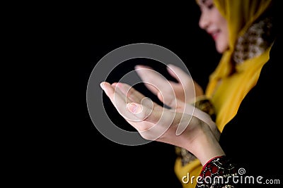 Religious young Muslim two women praying over black background. Stock Photo