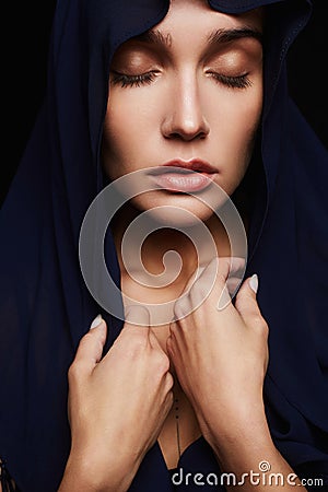 Religious young woman in hood Stock Photo