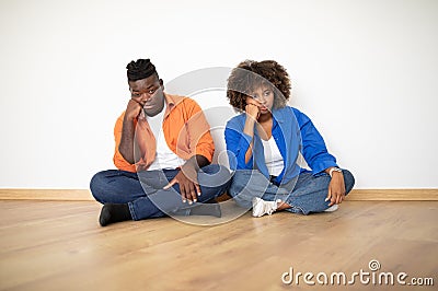 Relocation Problems. Upset Bored Black Couple Sitting On Floor In New Apartment Stock Photo