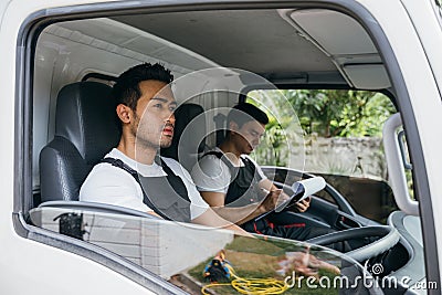 Relocation service, Mover workers driving truck for transporting furniture Stock Photo