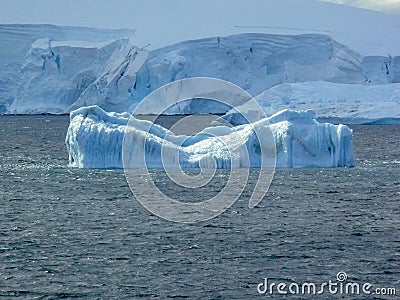 Eroded blue iceberg floats in the Lemaire Channel Antarctica Stock Photo