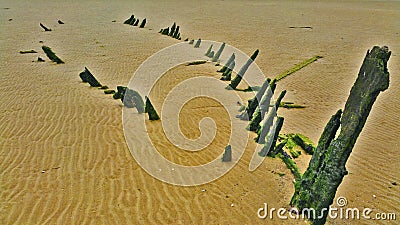 The remains of a boat on yellow sand Stock Photo