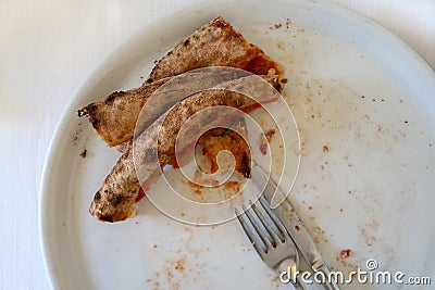 Remains of pizza which has been eaten, only burned edges left Stock Photo