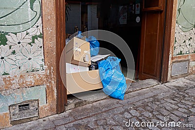 Remains of trash and garbage, plastic bags and cardboard boxes in the portal of a house in Toledo, Spain Editorial Stock Photo