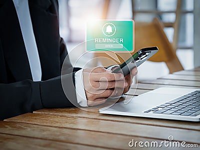 Reminder alert notification with bell icon pop-up message on smart mobile phone screen in hands of business person. Stock Photo