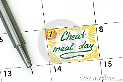 Reminder Cheat Meal Day in calendar with green pen. Stock Photo