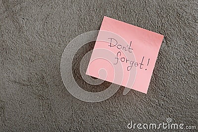 a reminder - don't forget written on color sticker notes on cement background Stock Photo
