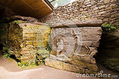 Remnants of ancient pagan cave temple with figures of tree, woman and deer carved in stone, symbols of life, maternity and clan Editorial Stock Photo