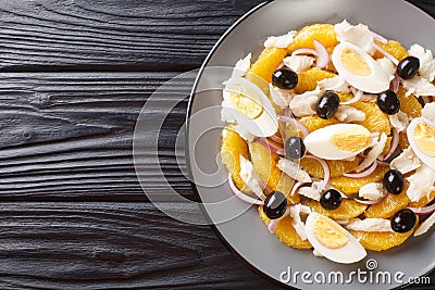 Remojon salad of oranges, boiled salted fish, eggs and red onions close-up in a plate. Horizontal top view Stock Photo