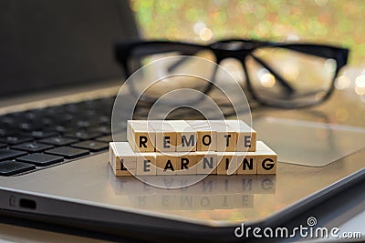 REMOTE LEARNING virtual learning concept with wood block letters on laptop Stock Photo