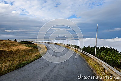 Remote mountain service road with clouds Stock Photo