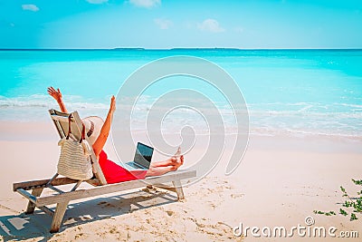 Remote work concept -happy young woman with laptop on beach Stock Photo