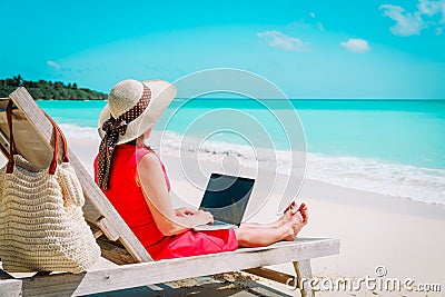 Remote work concept -young woman with laptop on beach Stock Photo