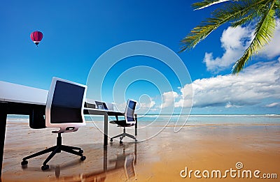 Remote work office desk and chairs on a sand beach Stock Photo