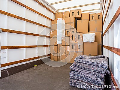 Removal van interior, stacked boxes and blankets. Copy space. Stock Photo