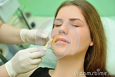 Removing the mustache of a woman with hot wax in a beauty salon Stock Photo