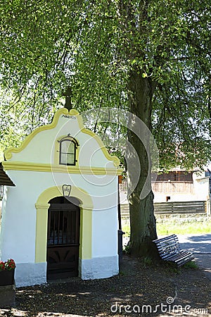 Renaissance chapel with cross by tree in village Frydstejn Stock Photo