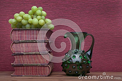 Renaissance, wine carafe, bottle, old books and grapes Stock Photo