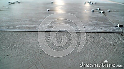 Renovating the floor. Construction workers laying tile over concrete floor using tile levelers, notched trowels and tile Stock Photo