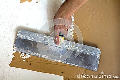 Renovation workers hand plastering the wall Stock Photo