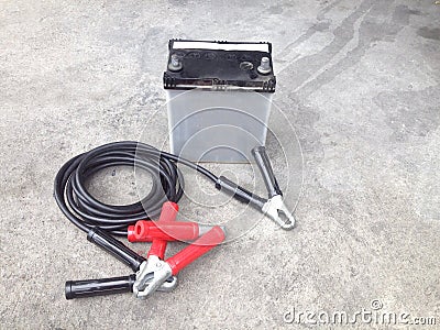 Repair of car batteries with Car battery charger at dirty parking , Bulbs, fluids and battery Stock Photo