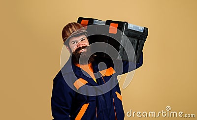 Repair home. Repairman in protective helmet with toolbox. Handyman, craftsman with repair kit. Smiling bearded man in Stock Photo