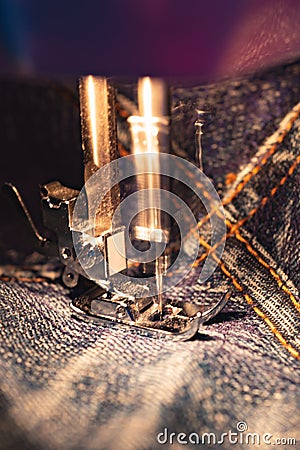 Repair jeans on the sewing machine. View of the fabric, needle and thread. Real motion blur Stock Photo