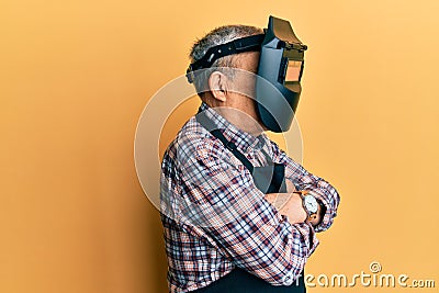 Repair man wearing professional welding mask over head covering face for protection Stock Photo