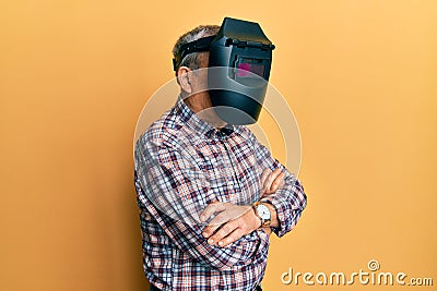 Repair man wearing professional welding mask over head covering face for protection Stock Photo