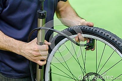 repair mountain bike in the workshop. pump the bike wheel. close-up mechanic Stock Photo