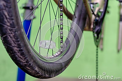 Repair mountain bike in the workshop. Replacing an old rusty chain with a new one. Tool for make chain removal and installation. Stock Photo