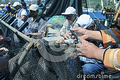 A fishnet repairer by hands Editorial Stock Photo