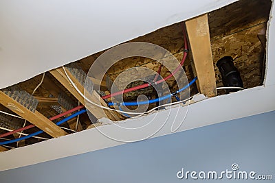 Repair plumbing line with a leaking pipe in a ceiling Stock Photo