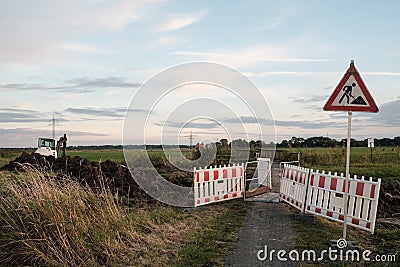 repair of a rural road, a warning sign, a fence and special equipment Stock Photo