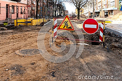 repair of sidewalks and roads in the city. A section of the street closed from traffic. A road sign signifying a dangerous zone Stock Photo