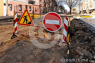 repair of sidewalks and roads in the city. A section of the street closed from traffic. A road sign signifying a dangerous zone Stock Photo