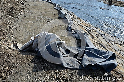 Repair of the slope above the river, the river banks are strengthened by a bunch of stonemasons where the embankment is paved with Stock Photo