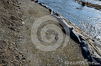Repair of the slope above the river, the river banks are strengthened by a bunch of stonemasons where the embankment is paved with Stock Photo