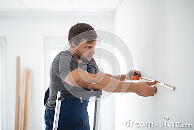 Repair team measures the wall before renovation of the living room Stock Photo