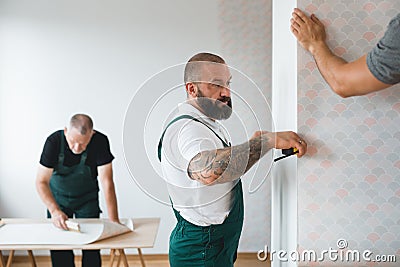 Repair team measures the wall before renovation of the living room Stock Photo