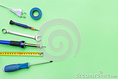 Repair tools on a green background. Measuring tape, screwdriver, soldering iron. Place for text. Copy space. Flat lay Stock Photo