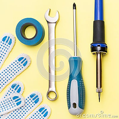 Repair tools on a yellow background. Measuring tape, screwdriver, construction gloves. Flat lay. Top view. Handyman tool Stock Photo