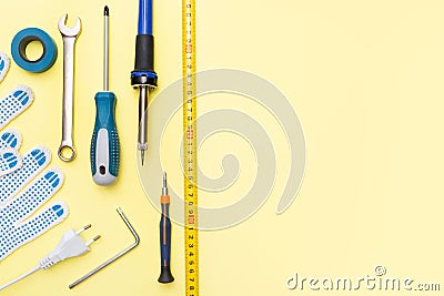 Repair tools on a yellow background. Measuring tape, screwdriver, construction gloves. Place for text. Copy space. Flat Stock Photo