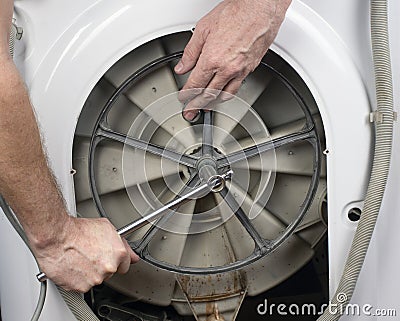 Repair of washing machines. Plumber removes parts from a washing machine Stock Photo